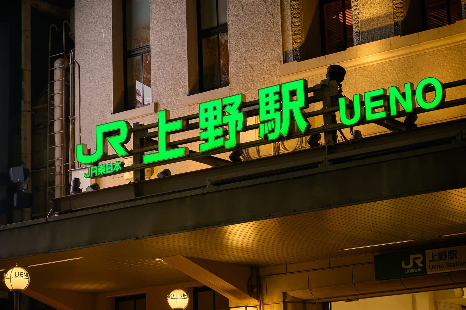 夜に緑色に光るJR上野駅の駅名サイン